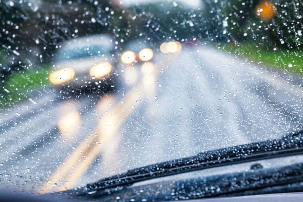 Car driving through heavy rain in Miami with increased car accident risk